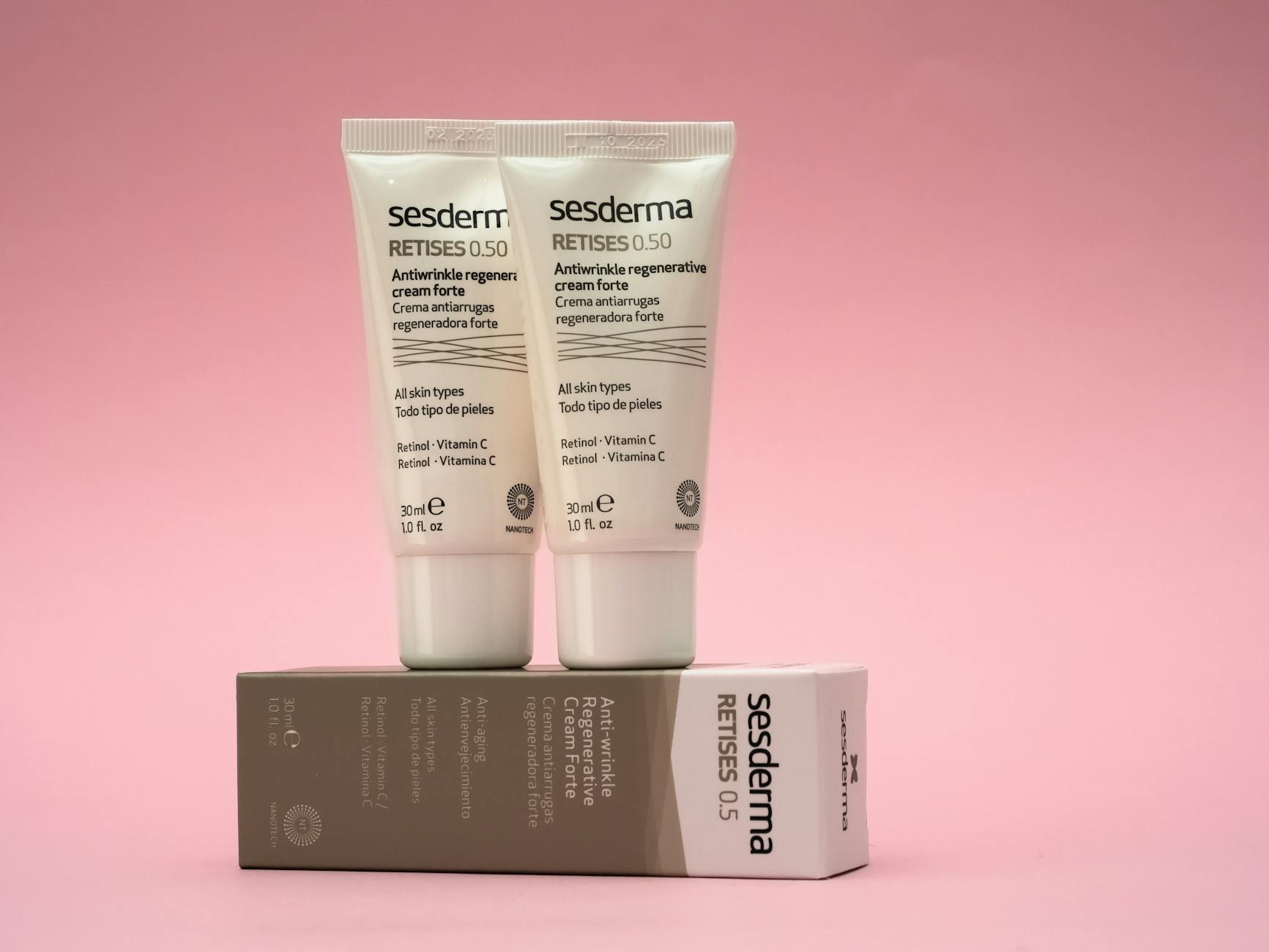 Dwa kremy przeciwzmarszczkowe Sesderma Retises na różowym tle