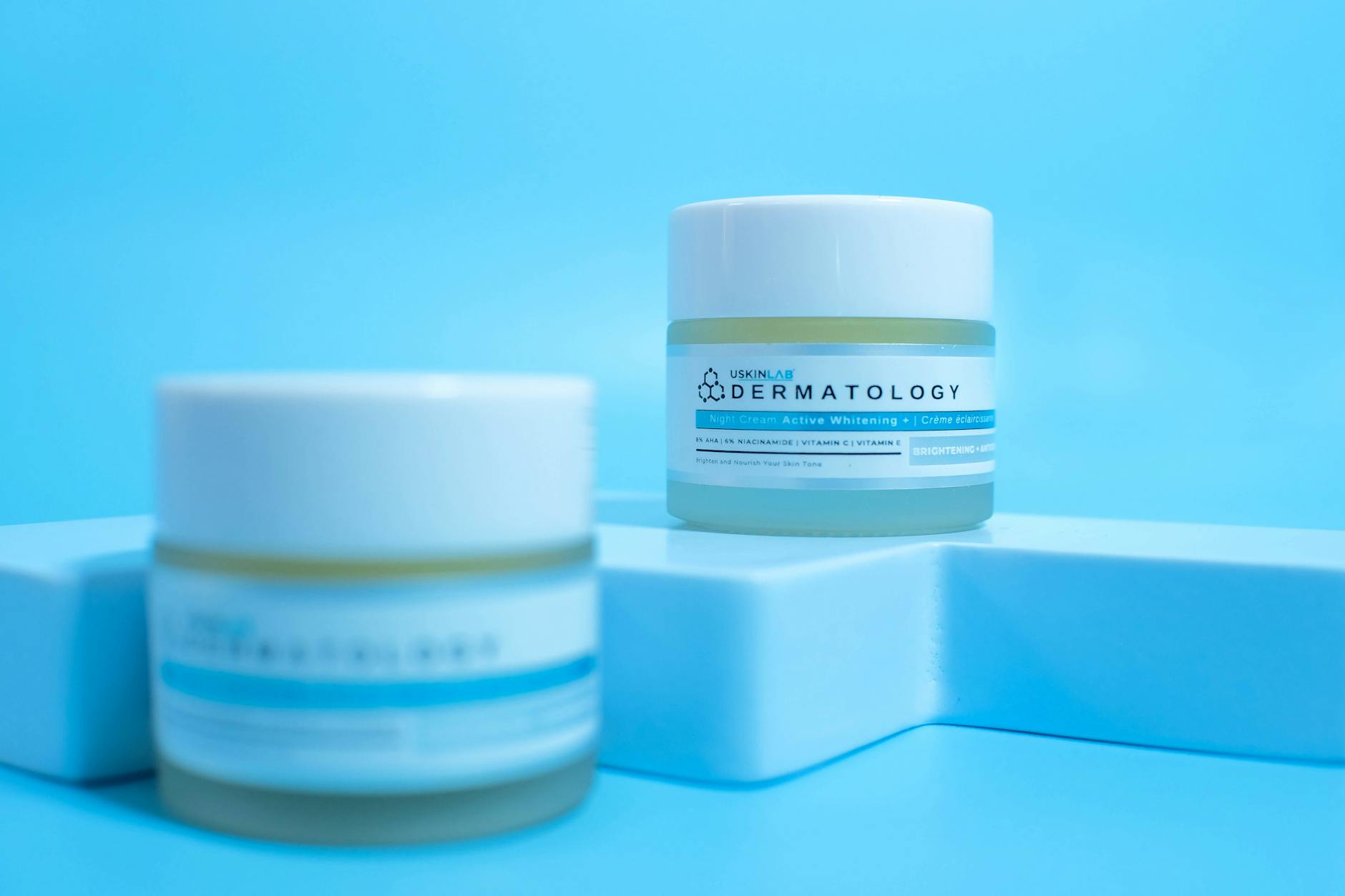 Słoiczki kremów do twarzy na niebieskim tle