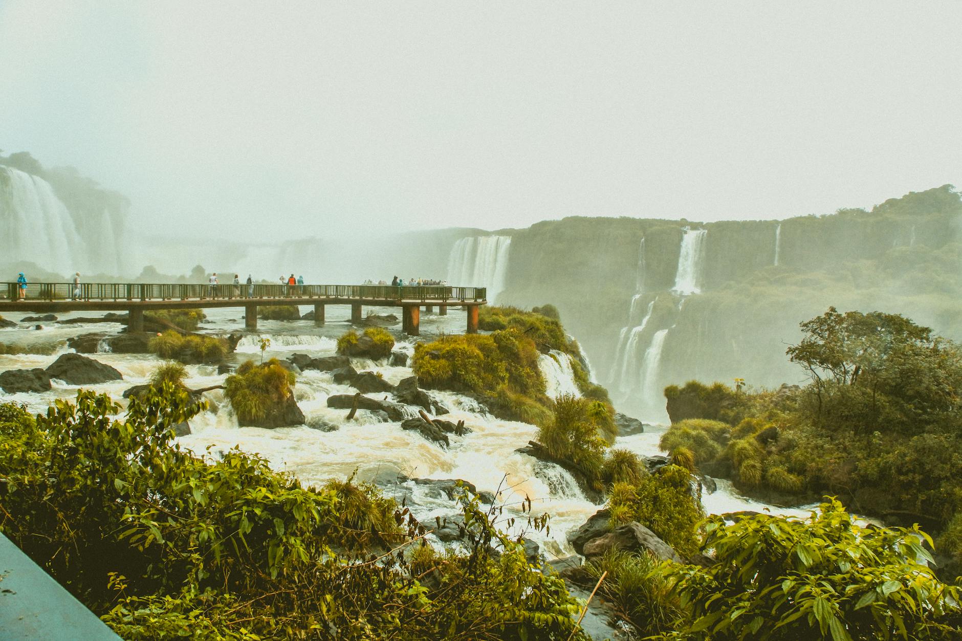 Turyści na kładce nad potężnymi wodospadami w tropikalnej Brazylii