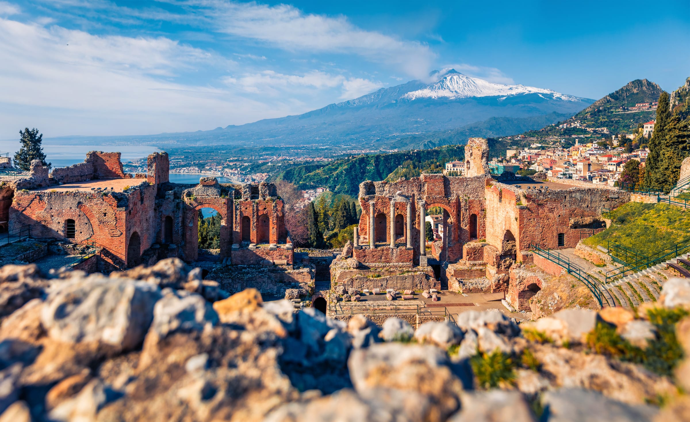 Wspaniały poranny widok na miasto Taormina i wulkan Etna w tle. Zachwycający wiosenny widok na starożytny teatr grecko-rzymski – Sycylia, Włochy, Europa. Motyw podróżniczy.